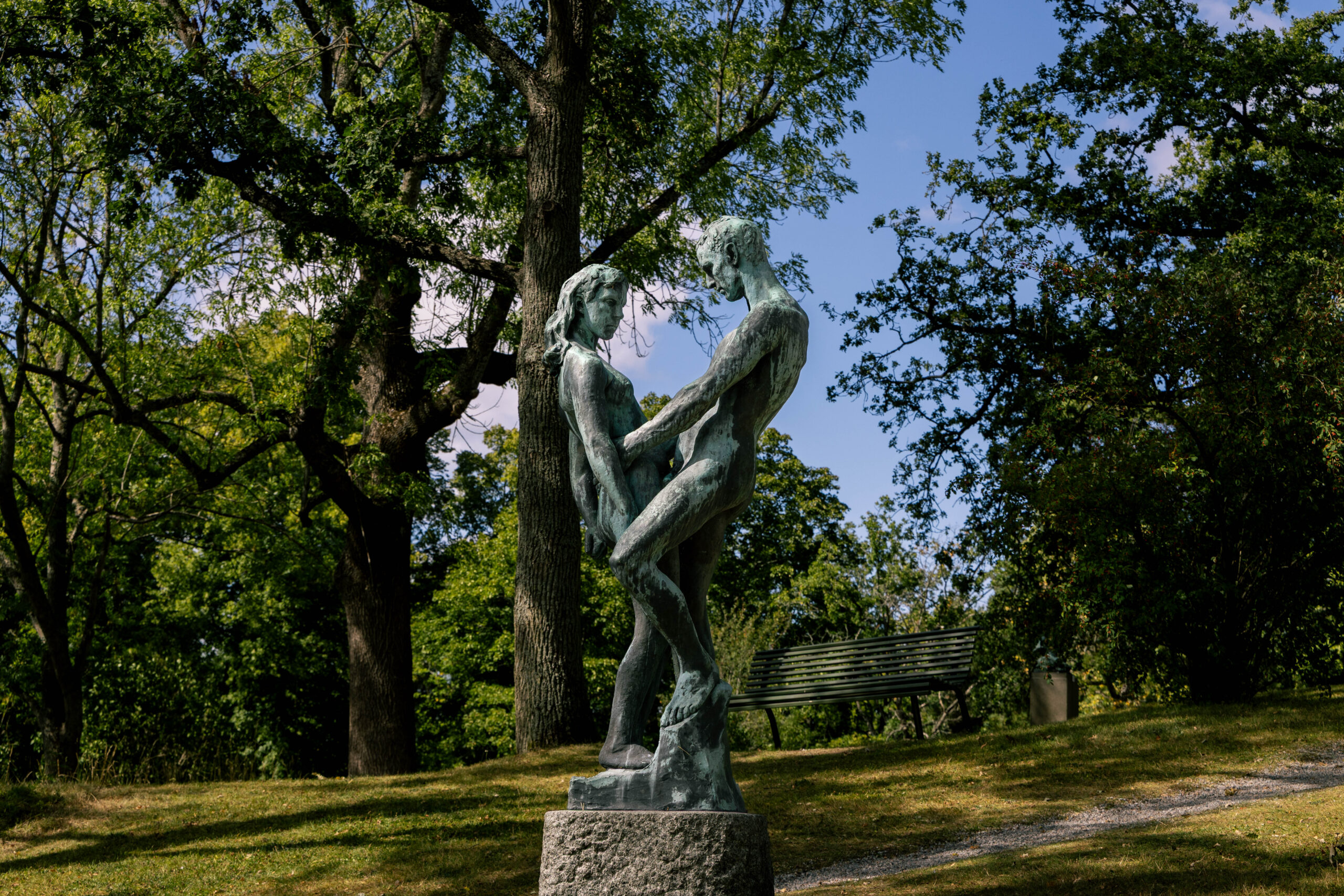 Garden scene with a statue of a man and a woman.