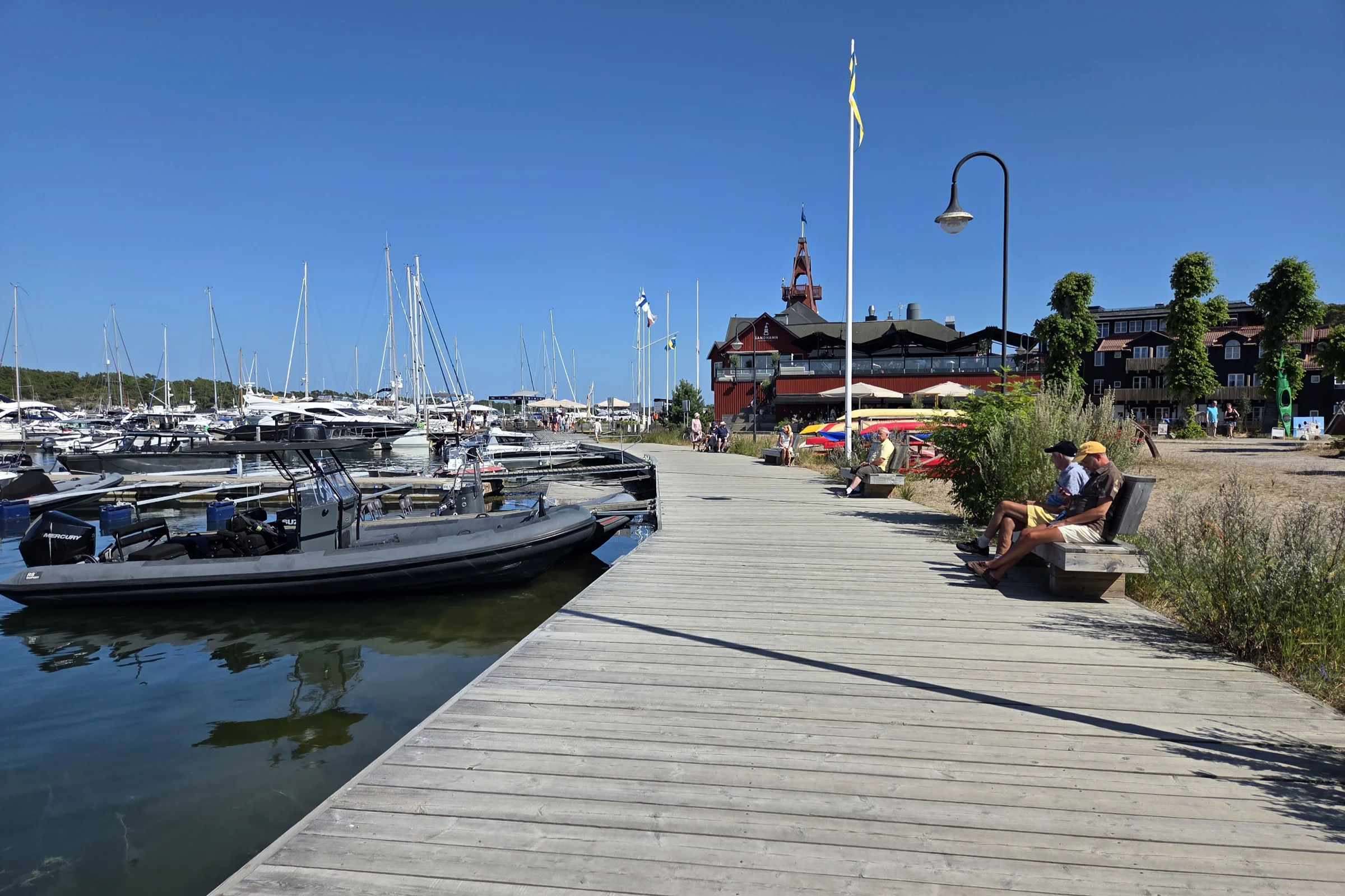 The main harbor at Sandhamn in the summer, with boats tied to the pier and the hotel in the background.