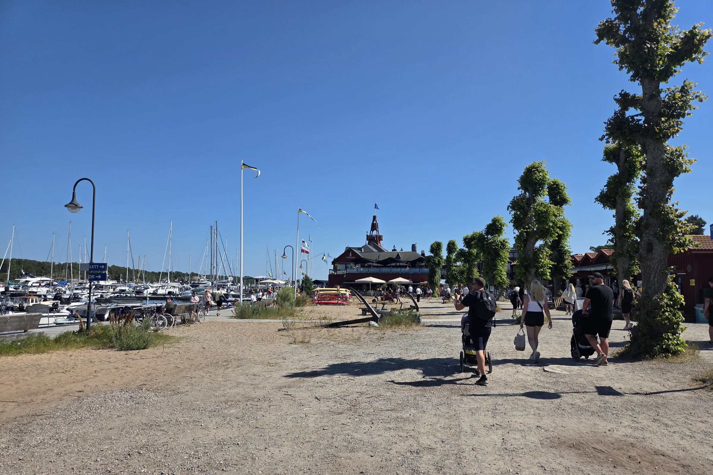 Sandhamn harbour on a summer day with its waterside promenade and three alley.