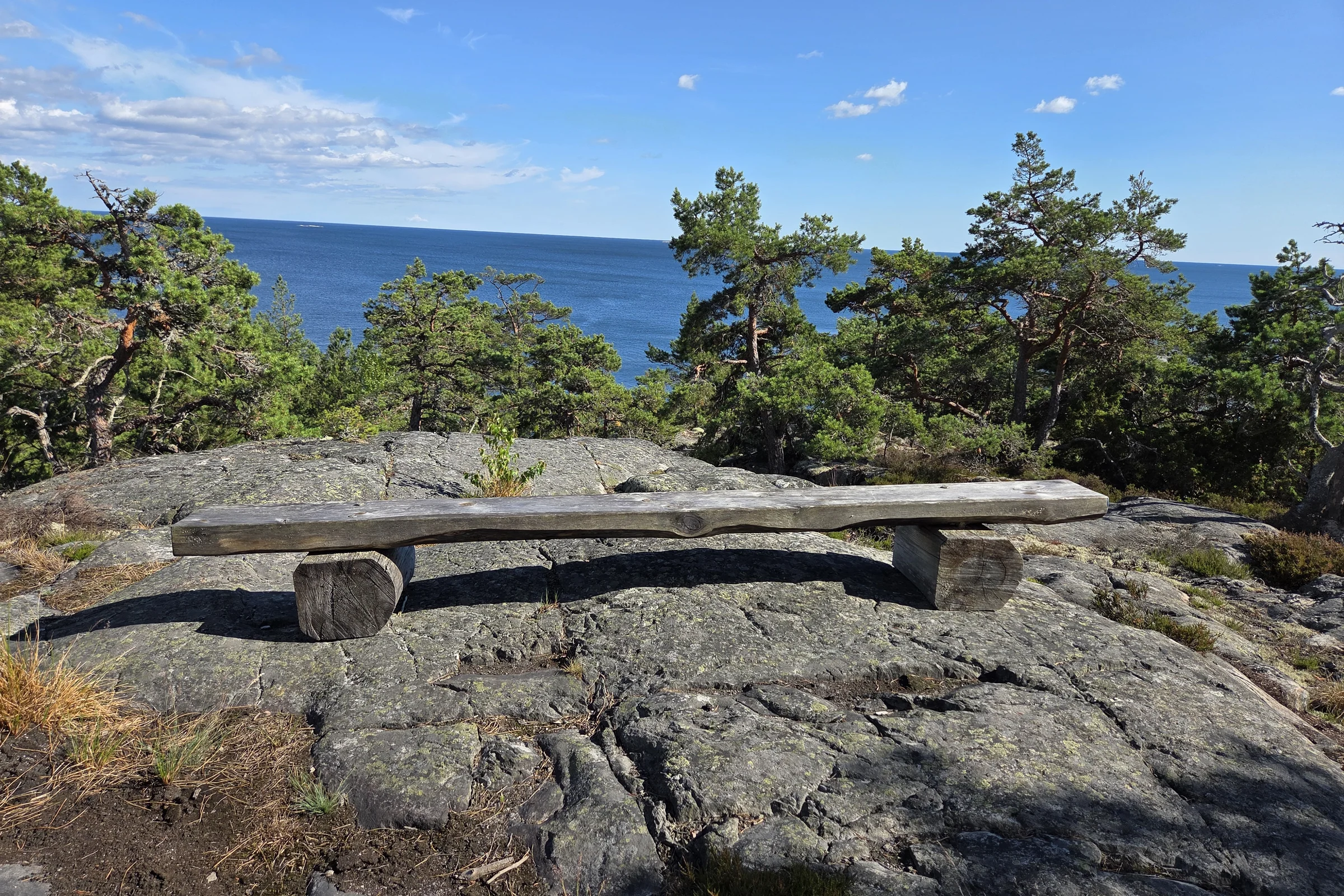 A bench at a cliff at Utö during a sunny summer day.