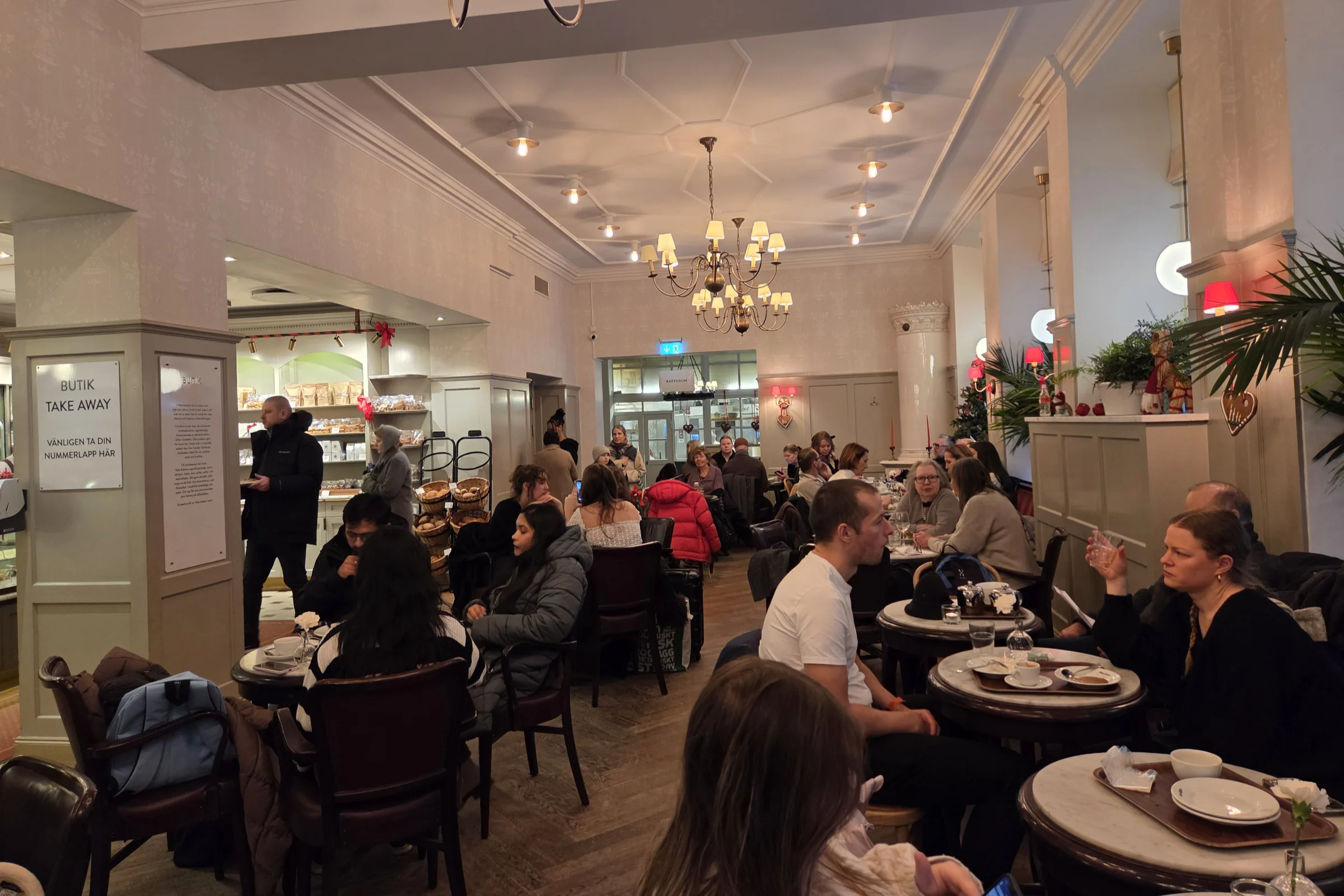 The café Vete-Katten on Kungsgatan during a winter day, with guest having a Swedish fika with coffee, tea and pastries.